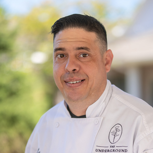 Nathaniel “Nate” Bennett, Culinary Director at Curtis Creek Senior Living, smiling in a professional outdoor headshot wearing a white chef coat.