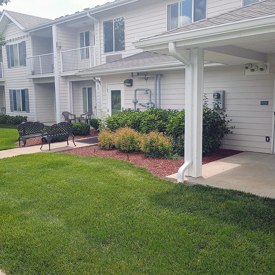 The exterior of Curtis Creek Senior Living featuring landscaped grounds.